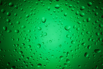 Green water drops on glass surface