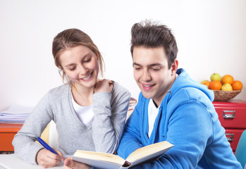 Zwei lachende Studenten lesen in einem Buch