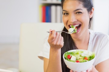 Happy businesswoman eating healthy salad