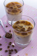 Top view of glasses with milk and coffee ice cubes