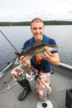 Happy fisherman with zander fishing trophy