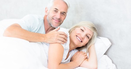 Portrait of a smiling mature couple lying in bed