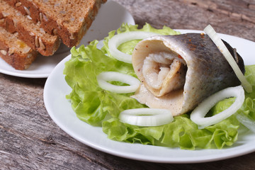 pickled herring roll and homemade bread on a plate.