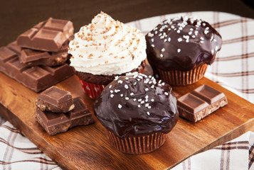 Chocolate cupcakes decorated with glaze and cream