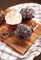 Chocolate cupcakes decorated with glaze and cream