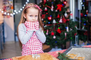 Adorable little girl in wore mittens baking Christmas