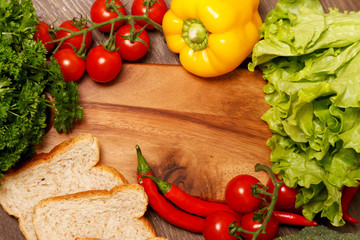 Bread slices and vegetables by the cutting board