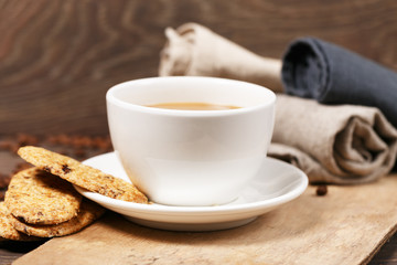 A white cup on a wooden background and biscuits