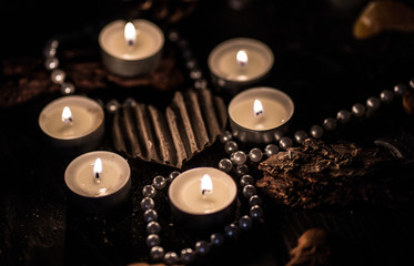 Candles and beaded necklace surrounding a heart