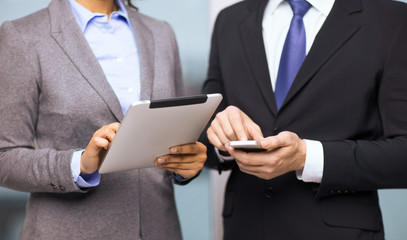 two businesspeople with smartphone and tablet pc