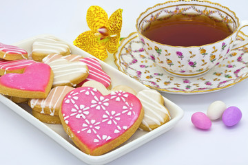 Fototapeta na wymiar Tea served in an antique cup with heart shaped cookies.