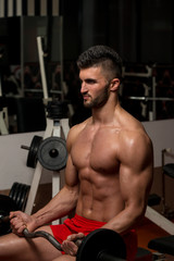 Fototapeta na wymiar Man Lifting Barbell In Gym