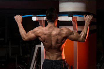 Fototapeta na wymiar Muscular Young Man Exercising In Gym