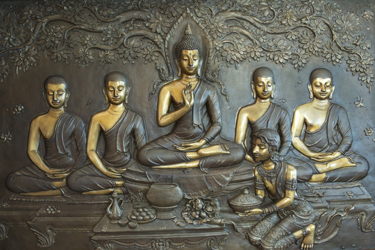 Buddha life scenes on carved metal at the temple in Thailand.
