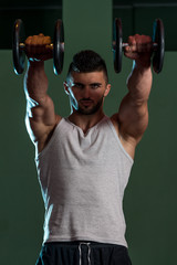 Fototapeta na wymiar Muscular Men Exercising Shoulder With Dumbbells