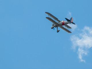 Biplane in Flight Giving Rides in a Blue Sky with Fluffy Clouds