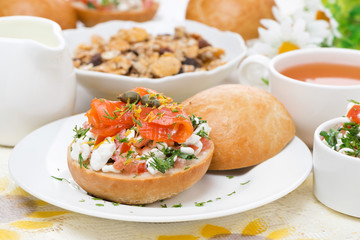 bun with cottage cheese, herbs, tomato and salmon for breakfast