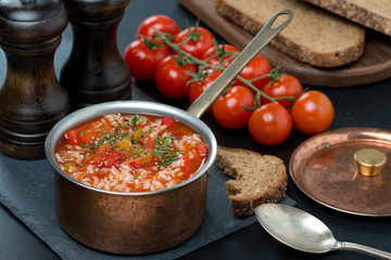Spicy tomato soup with rice and vegetables in a saucepan