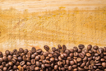 Background with coffee beans and light wood texture, with room for text	