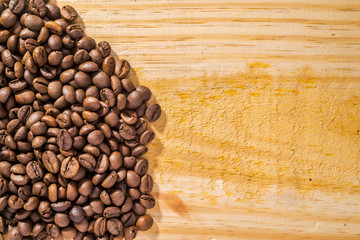 Background with coffee beans and light wood texture, with room for text