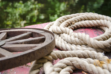 Fototapeta premium Old rolled ropes and a rusty wheel
