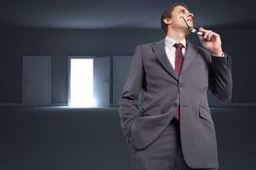 Composite image of thinking businessman holding his glasses