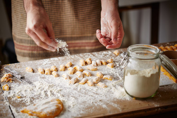 Cook preparing raw pumpking gnocchi