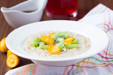 Oat porridge with fruit, orange, cumquat, kiwi, maple syrup