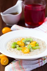 Oat porridge with fruit, orange, cumquat, kiwi, maple syrup