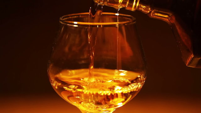 Cognac, brandy is poured from a bottle