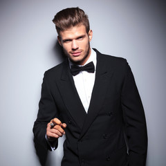 happy elegant man smiling while smoking a cigar
