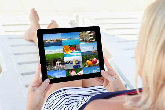 girl in a bathing suit lying on a chaise lounge with a tablet an