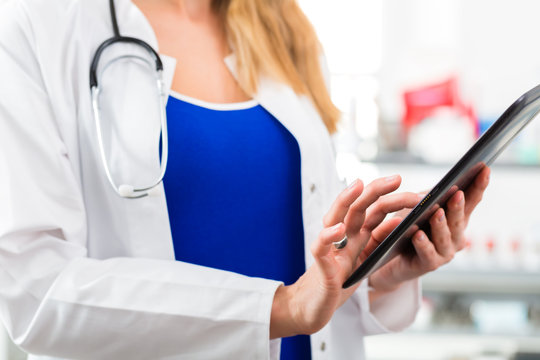 Ärztin in Praxis liest eine digitale Krankenakte