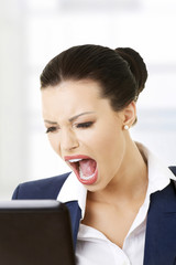 Angry businesswoman shouting on her laptop