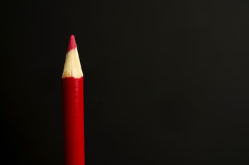 Red pencil crayon on a black background