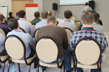 The audience listens  in a conference hall