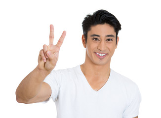 Happy, smiling young man holding up peace sign