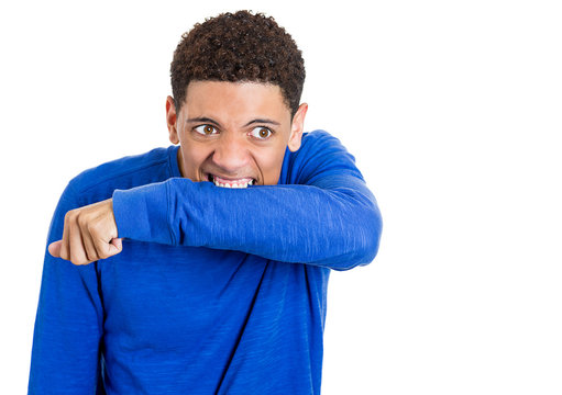 Crazy, insane young man biting his arm