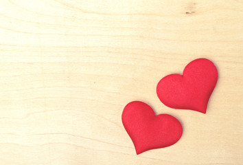 two red hearts on a wooden  board