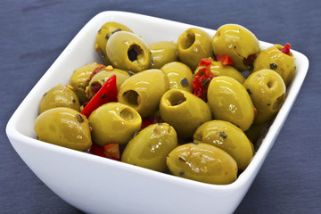 Spicy green olives in a china dish.