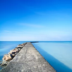 Deurstickers Pier Beton en rotsen pier of steiger op blauw oceaanwater