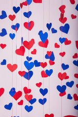 Background of red and blue paper hearts hanging on strings