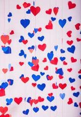 Background of red and blue paper hearts hanging on strings