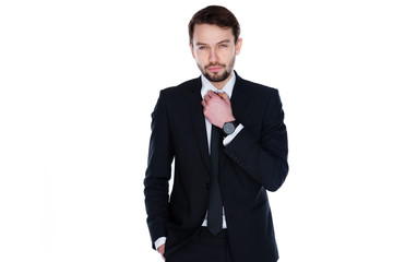 Handsome businessman adjusting his tie