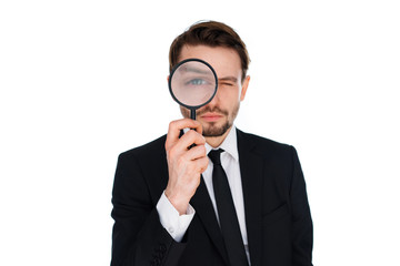 Businessman looking through a magnifying glass