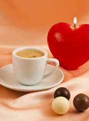 Cup of coffee with chocolates on  silk