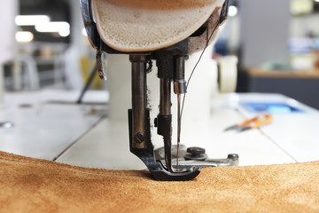 Closeup of sewing machine working part with leather