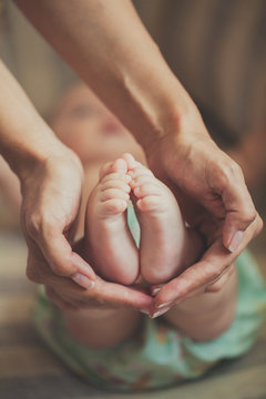 Masseur massaging little baby's foot, shallow focus