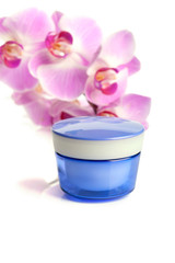 Pot of face/body cream and beautiful orchid flowers