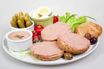 plate with slices of bread with home made pate, vegetables, eggs